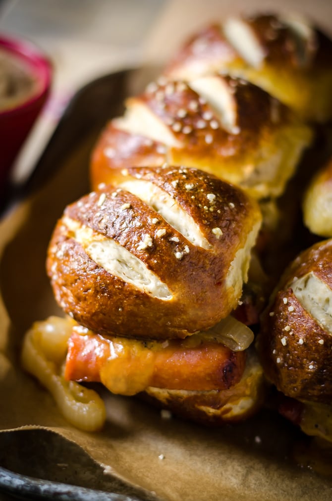 Bratwurst Sliders with Beer Cheese and Beer Braised Onions. These loaded sliders are served on pretzel buns and are perfect for parties or football season! | hostthetoast.com