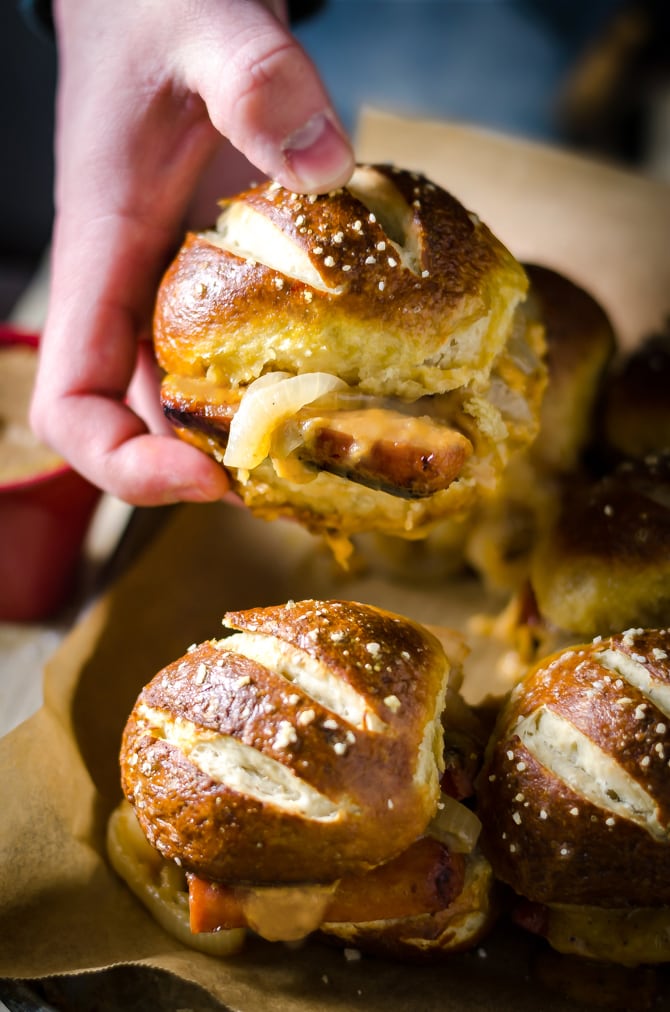 Bratwurst Sliders with Beer Cheese and Beer Braised Onions. These loaded sliders are served on pretzel buns and are perfect for parties or football season! | hostthetoast.com