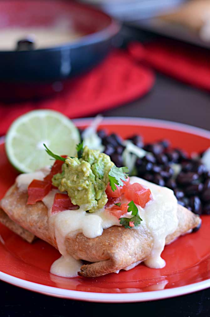 Baked Chicken Chimichangas with Monterey Jack Cheese Sauce.  These are so easy and a new family favorite!  They freeze and reheat well, too! | hostthetoast.com