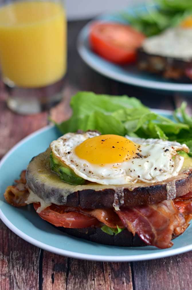 B.L.A.T Croque Madames.  Crispy bacon, fresh tomato and arugula, smoky cheddar cheese, creamy avocado, and a perfectly fried egg.  Does it get any better than that?  The answer is no, it does not. | hostthetoast.com