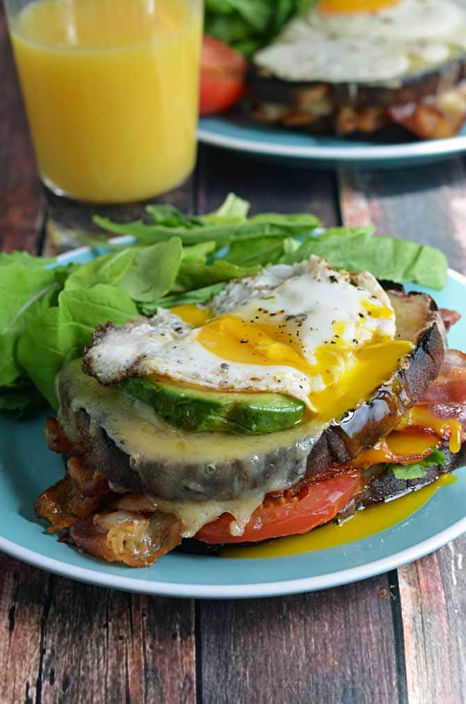 B.L.A.T Croque Madames.  Crispy bacon, fresh tomato and arugula, smoky cheddar cheese, creamy avocado, and a perfectly fried egg.  Does it get any better than that?  The answer is no, it does not. | hostthetoast.com