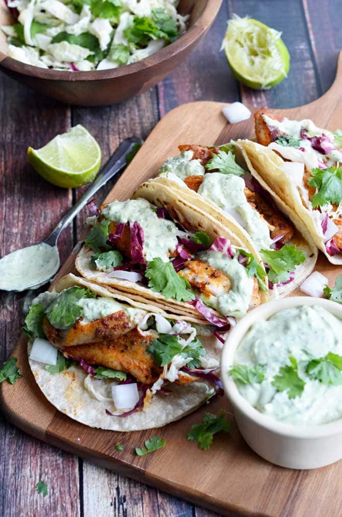 Blackened Fish Tacos with Avocado-Cilantro Sauce. These were some of the BEST tacos I've ever had! This recipe uses tilapia, but you can also try it with salmon, catfish, or whatever your heart desires! You can't go wrong with this recipe. | hostthetoast.com