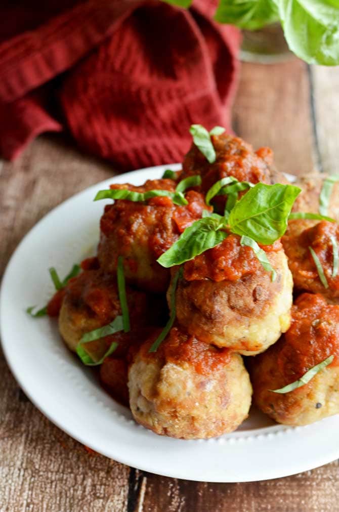 Mozzarella-Stuffed Chicken Parm Meatballs!  All the flavors of chicken parmesan in a fun-to-eat bite!  Click through to see a picture of the mozzarella-y inside and get the recipe!  | hostthetoast.com