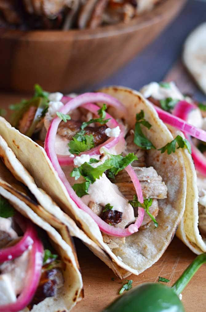 Crock Pot Carnitas Tacos. Super crispy and juicy with no added lard! Way easier to make in the crock pot and delicious with quick pickled onions, jalapenos, and chipotle cream. My boyfriend is crazy about them! | hostthetoast.com