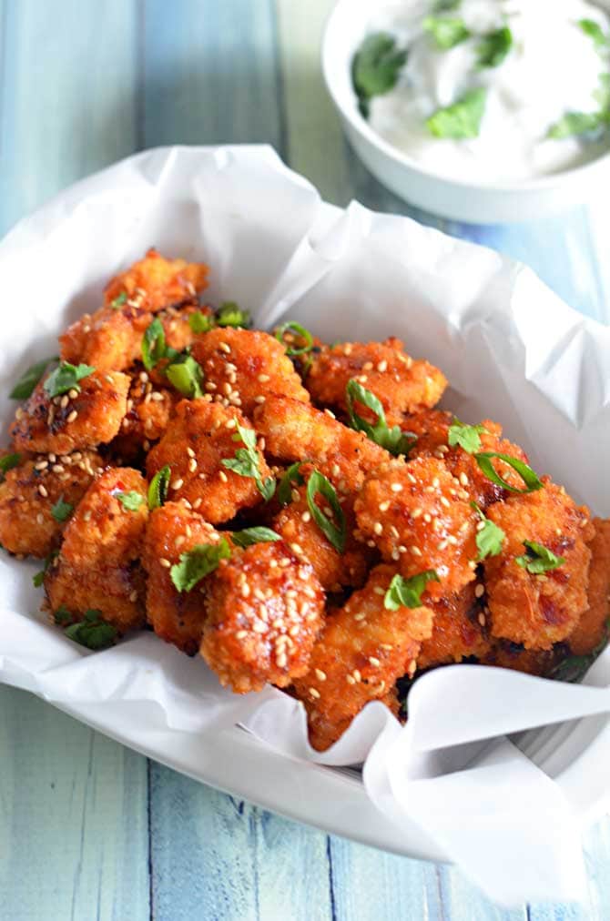 Baked Sweet Chili Garlic Popcorn Chicken.  I could eat these all day.  Great for Game Day and you won't even miss the fried wings! | hostthetoast.com