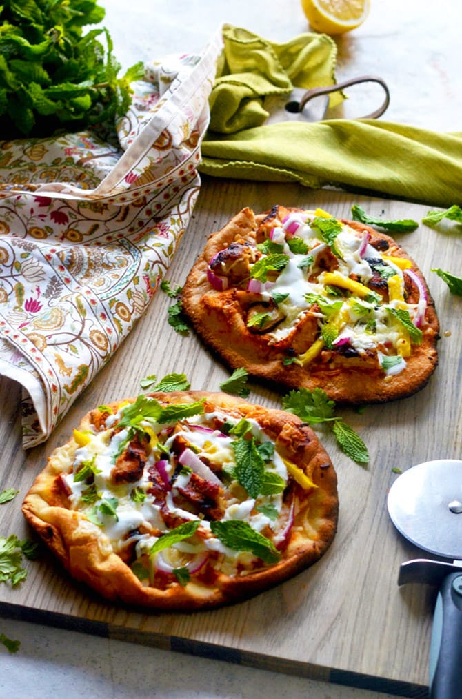 Tandoori Chicken Naan Pizzas. These grilled pizzas feature juicy tandoori chicken, mango, mozzarella, mint, cilantro, and yogurt. Premade naan make a great base for a delicious pizza dinner with Indian flair. | hostthetoast.com