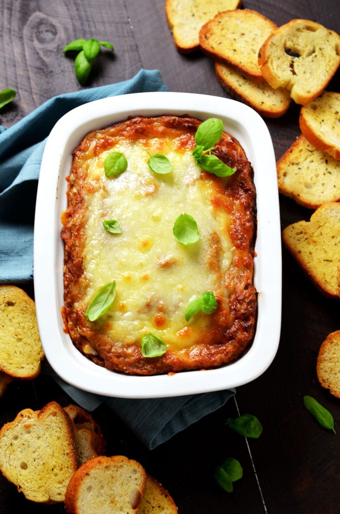 Eggplant Parmesan Dip. This warm, cheesy dip is loaded up with tomato sauce, garlic, and roasted eggplant. I love making it for winter parties. | hostthetoast.com