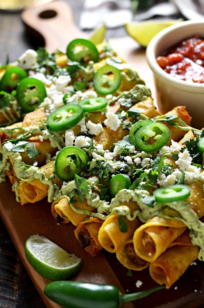 Jalapeño Popper Chorizo Taquitos with Creamy Avocado Sauce. These crunchy, rolled mini tacos are spicy, meaty, cheesy, and absolutely addictive. They make a great appetizer for Cinco de Mayo parties or a tasty treat of a dinner when served with rice and beans. They're great by themselves but with the cooling avocado sauce they get a 10/10 in my book. | hostthetoast.com