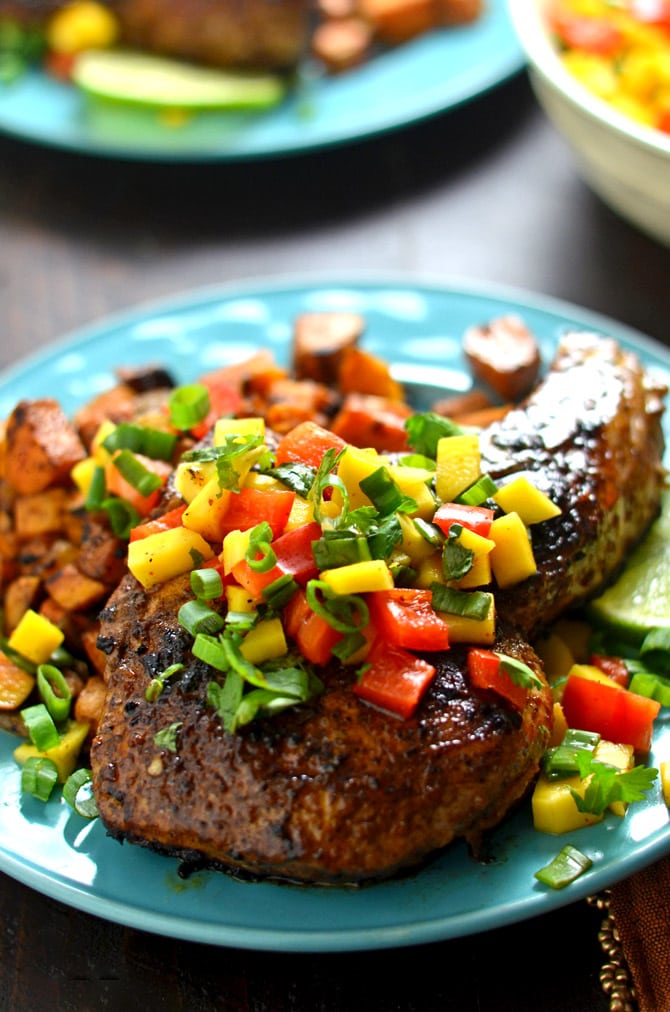 Jamaican Jerk Pork Chops with Curry Spiced Sweet Potatoes and Mango Salsa. A little heat, a little sweet, and a ton of Caribbean flavor combine in this simple dinner. | hostthetoast.com 