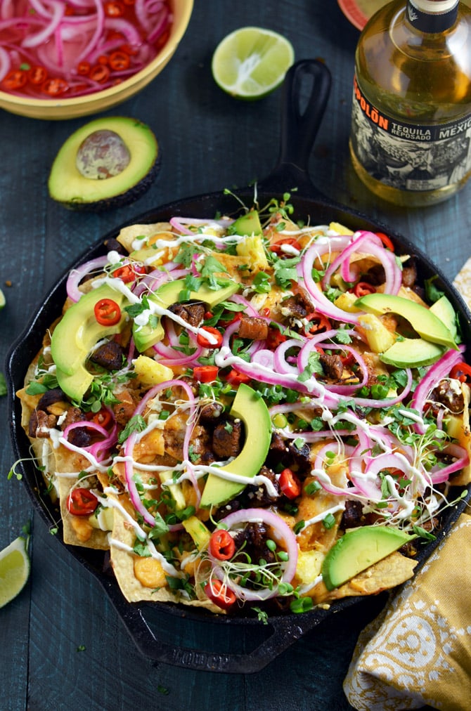 Nachos Al Pastor. These loaded nachos are piled with spicy, tangy pork, 3 kinds of cheese (including queso sauce), quick pickled onions and hot peppers, and more. This is how to do nachos the right way. | hostthetoast.com