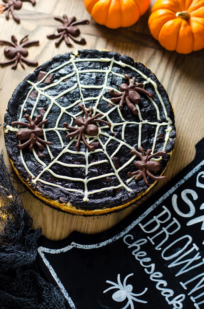 Spider Web S'more Cheesecake Brownies. This layered dessert features dark chocolate brownies, marshmallow cheesecake, and chocolate spiders. It's going to be a hit at your Halloween party! | hostthetoast.com