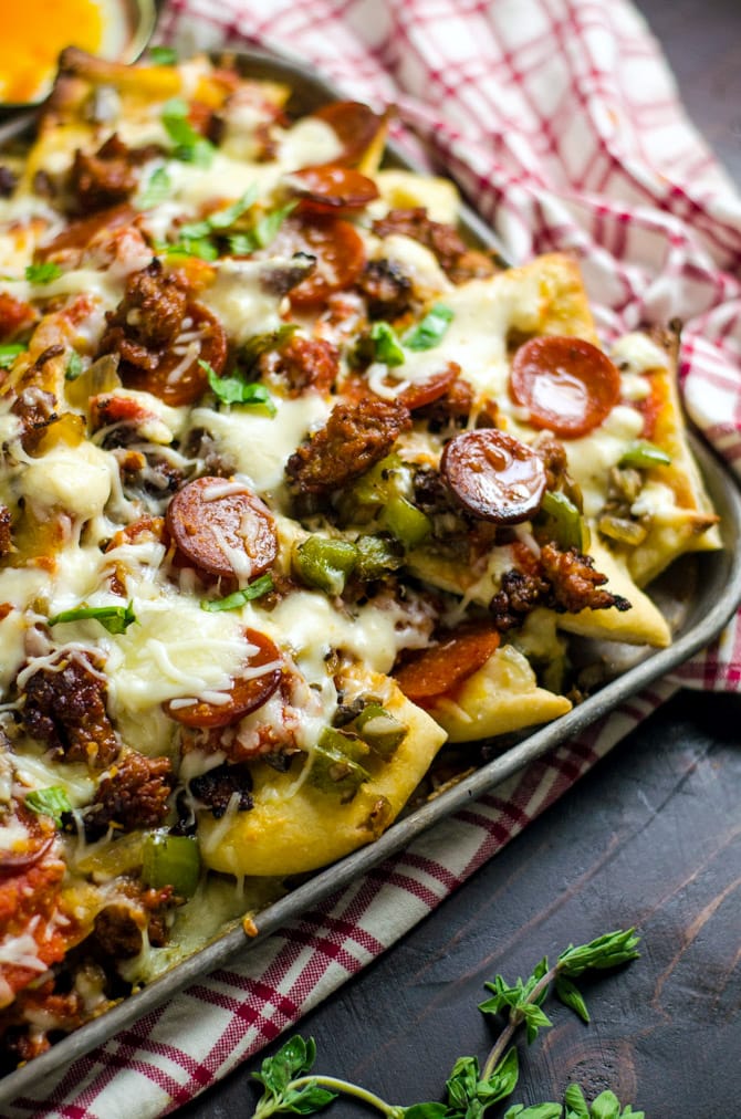 Loaded Pizza Nachos with Creamy Garlic White Sauce. All of your favorite pizza toppings on easy-to-make pizza crust chips. This is the ultimate appetizer. | hostthetoast.com