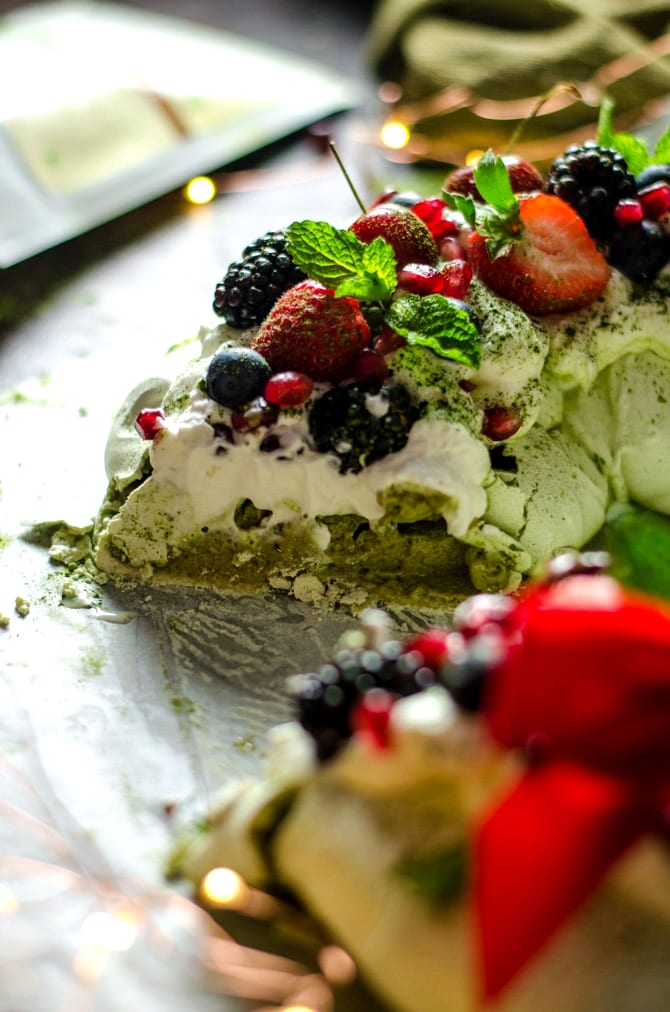 Matcha Christmas Wreath Pavlova. This sweet, smooth, and earthy-flavored dessert features a crisp crust and soft, marshmallowy center. Topped with whipped cream and berries, it makes a beautiful addition to your holiday table. | hostthetoast.com