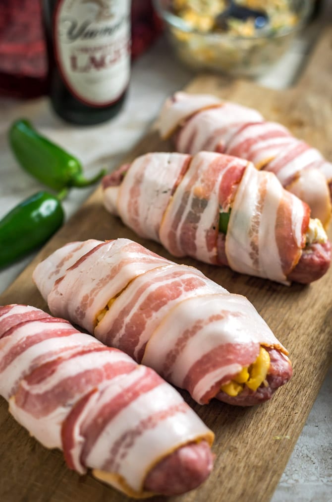 Bacon-Wrapped Stuffed Beer Bratwurst. Don’t just put the toppings on your beer brats, put them *in* them, too! Stuff ‘em, wrap ‘em in bacon, and grill ‘em until crisp. Click through for 4 filling ideas including mac & cheese, pimento cheese, sauerkraut, and jalapeño popper. | hostthetoast.com