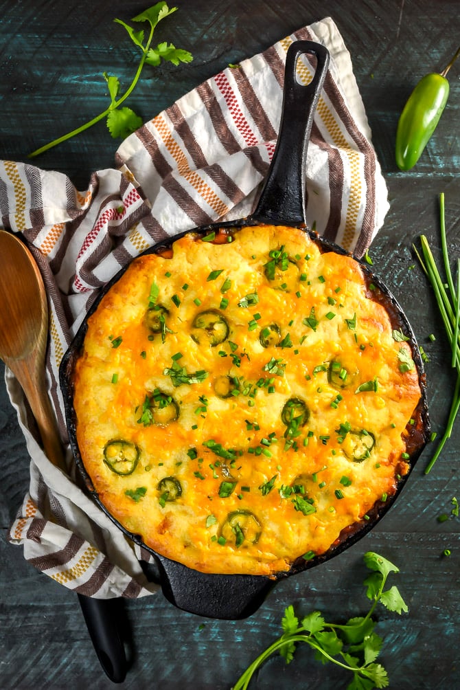 Skillet Cheddar-Cornbread BBQ Chicken Pot Pie. This easy recipe features a cheesy cornbread crust above tender chicken and vegetables in a barbecue sauce-based gravy. How's that for dinner? | hostthetoast.com