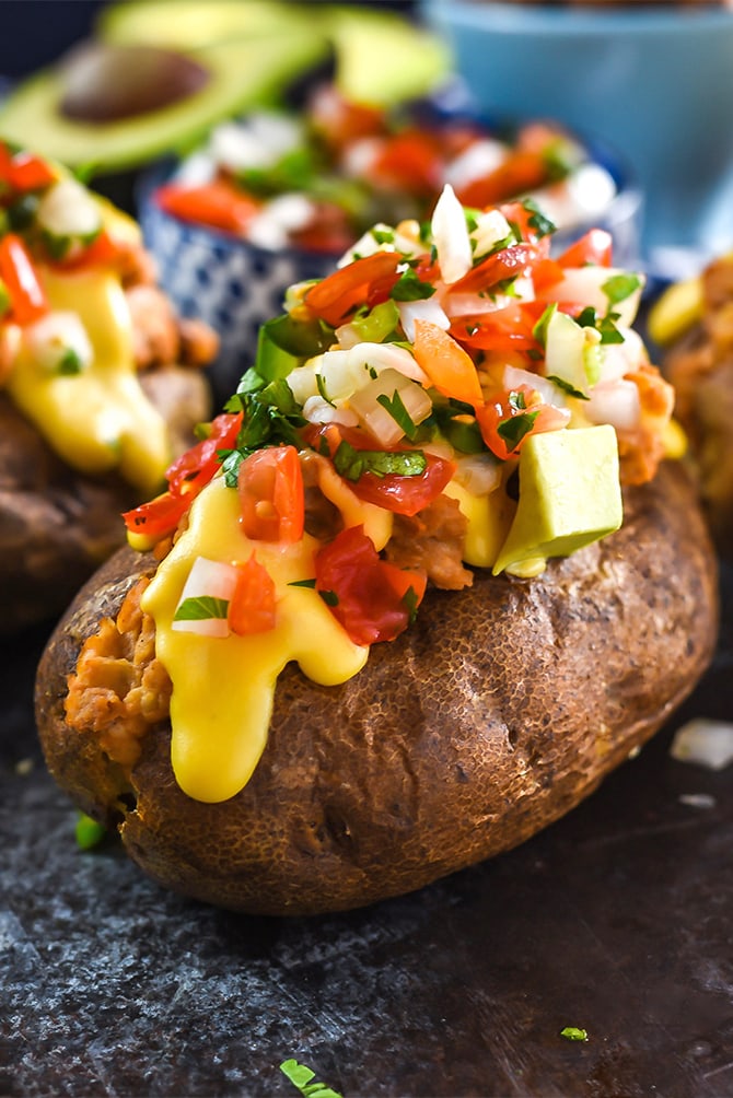 Nacho Baked Potatoes. These fluffy russets are loaded up with refried beans, sour cream, pico de gallo, avocado, and an easy queso cheese sauce. | hostthetoast.com