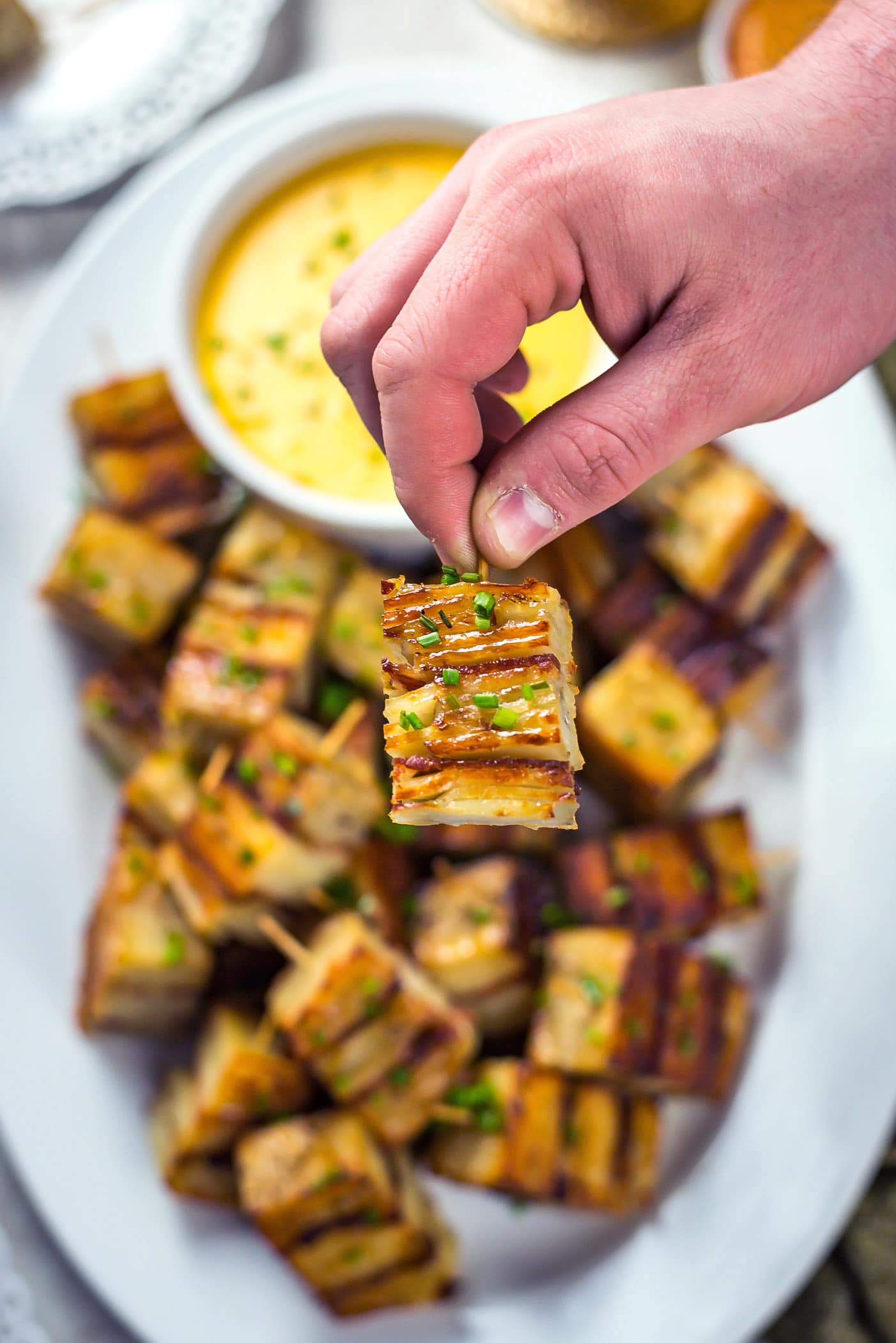 Party Potato Pave Bites with Cheese Sauce. Layered potatoes, bacon, and a creamy cheese sauce make this recipe a hit with a crowd! | hostthetoast.com