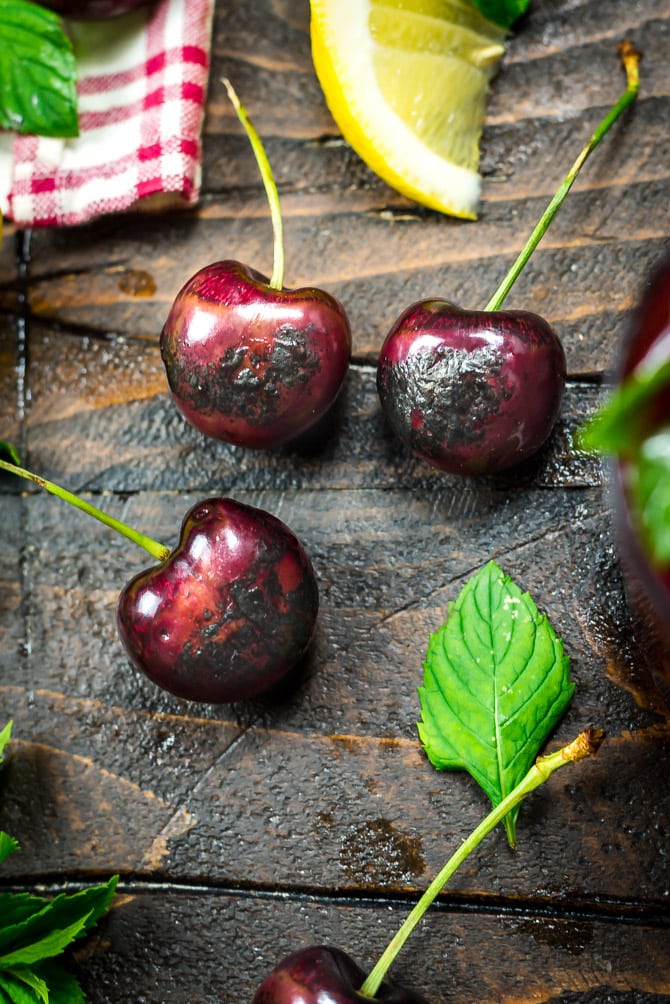 Charred cherries on a brown wooden table.