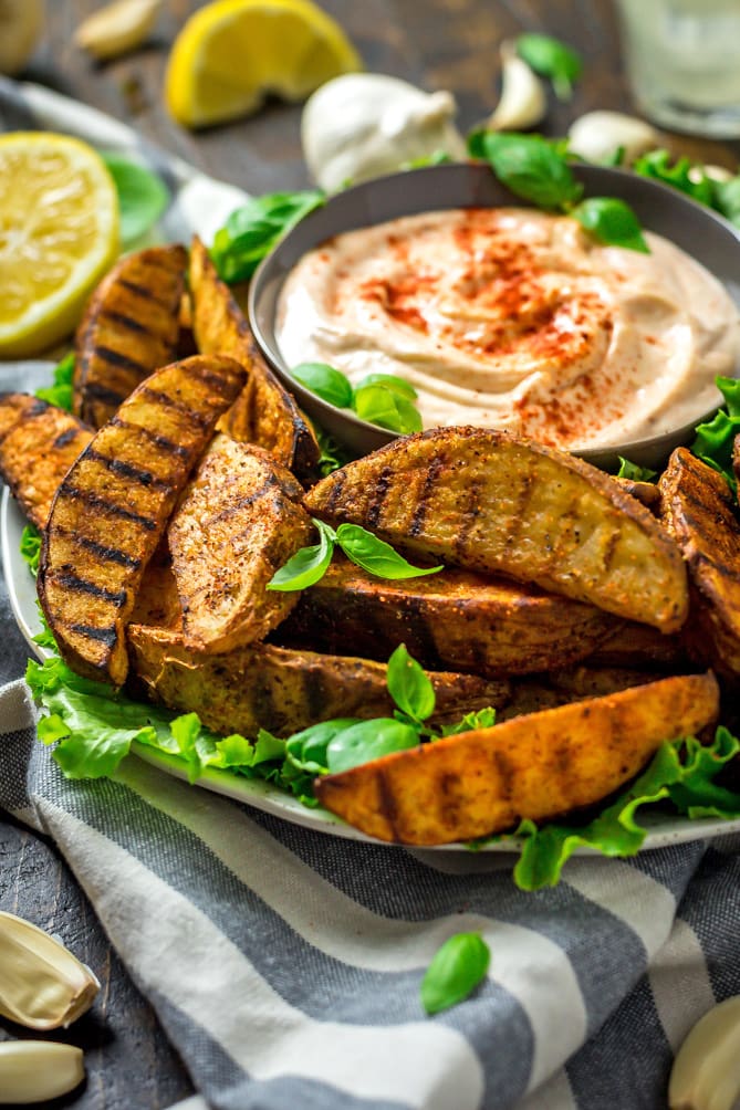 Grilled Potato Wedge Fries with Roasted Garlic Aioli. No burger is complete without a side of fries, so whip these easy grilled, seasoned wedges up for your next barbecue. The aioli, made from grill-roasted garlic, is just as addictive as the fries! | hostthetoast.com