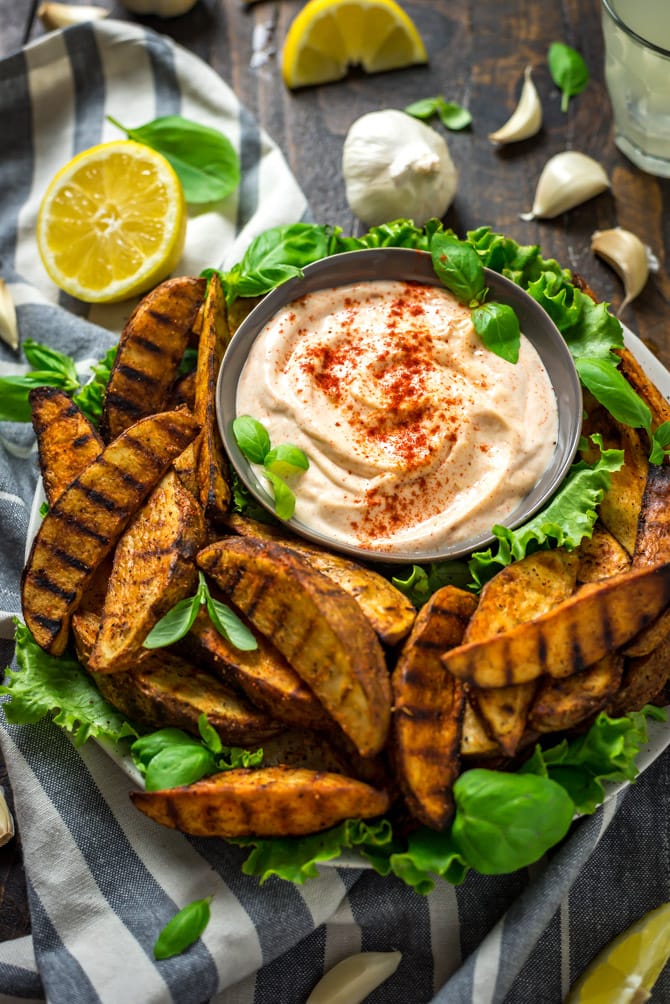 Grilled Potato Wedge Fries with Roasted Garlic Aioli. No burger is complete without a side of fries, so whip these easy grilled, seasoned wedges up for your next barbecue. The aioli, made from grill-roasted garlic, is just as addictive as the fries! | hostthetoast.com