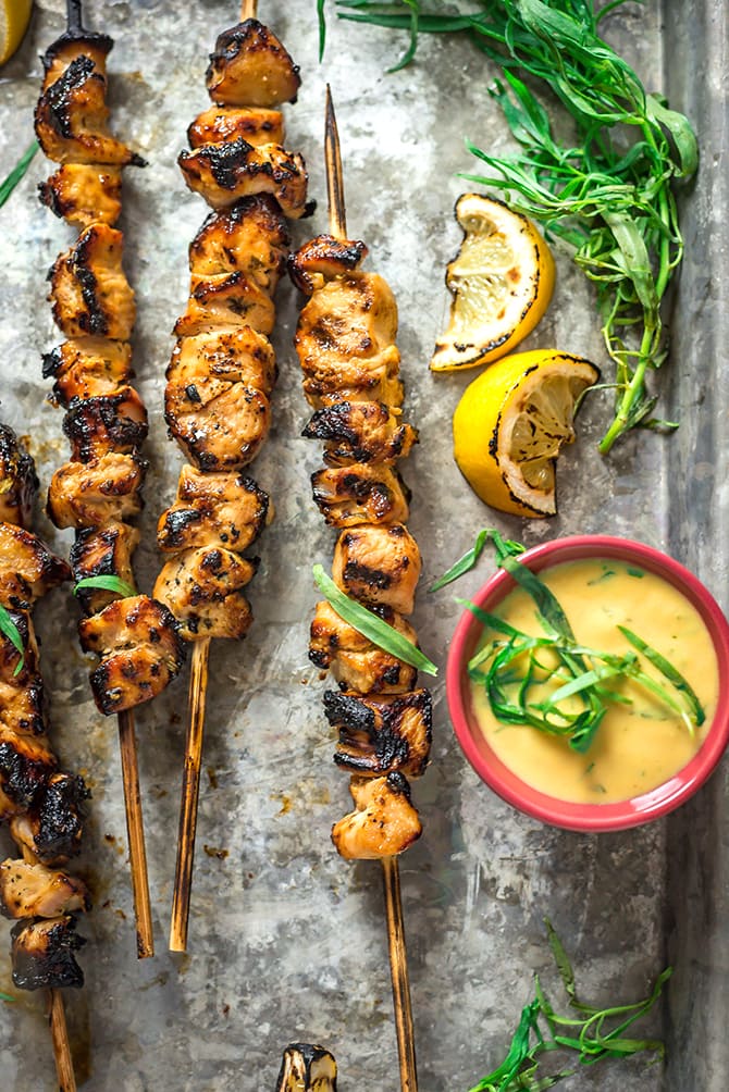 A close up of Tarragon Mustard Chicken Skewers with extra mustard on the side. 