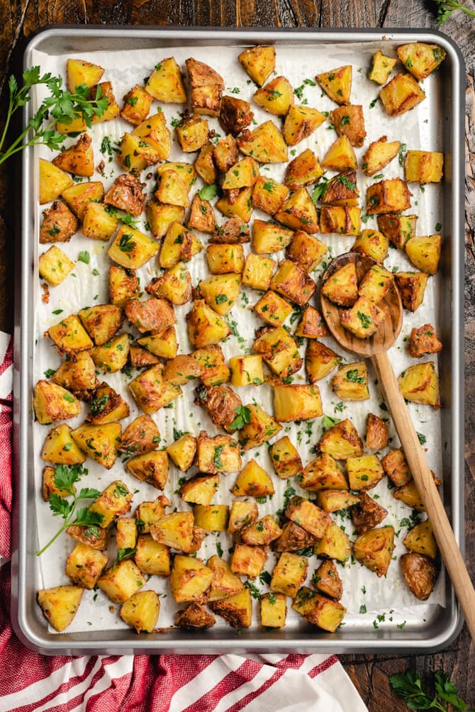 These easy-to-make Oven Roasted Red Potatoes are tossed with garlic, herbs, and parmesan cheese, and then baked until beautifully golden and crisp. Serve them as-is. or finish with butter and extra fresh parsley for a truly decadent and drooled-over side dish. 
