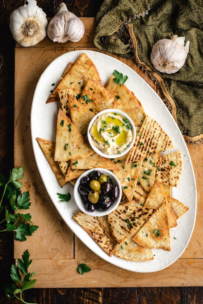 Learn how to make pita chips that crisp, golden brown, and delicious! These baked pita chips make tasty snacks on their own, or are fantastic for dunking in dips like hummus. I'll teach you how to make 4 varieties: Sea Salt, Garlic & Herb, Za'atar Seasoned, and Cinnamon Sugar!
