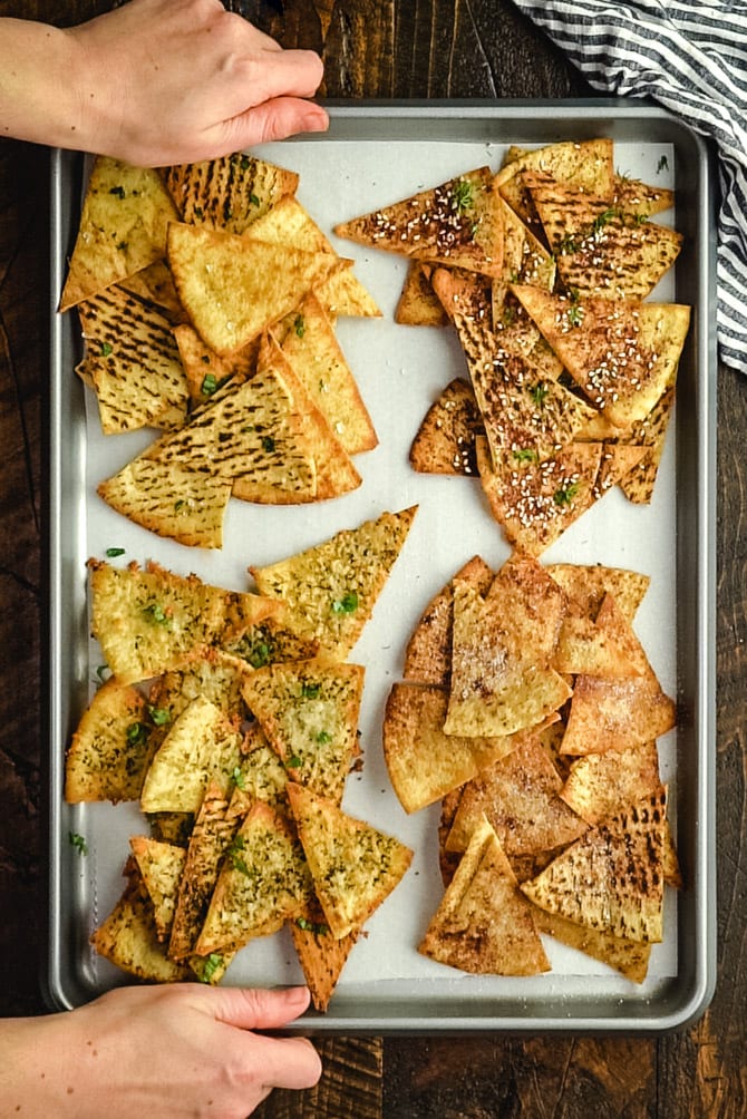 Learn how to make pita chips that crisp, golden brown, and delicious! These baked pita chips make tasty snacks on their own, or are fantastic for dunking in dips like hummus. I'll teach you how to make 4 varieties: Sea Salt, Garlic & Herb, Za'atar Seasoned, and Cinnamon Sugar!