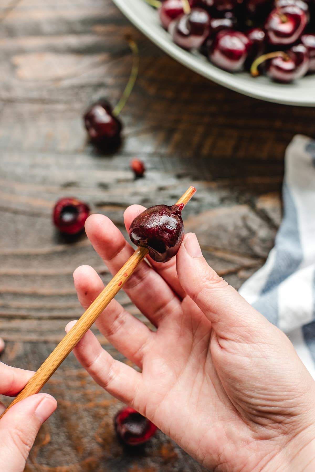 A wooden chopstick pushed through the center of the cherry to remove the pit