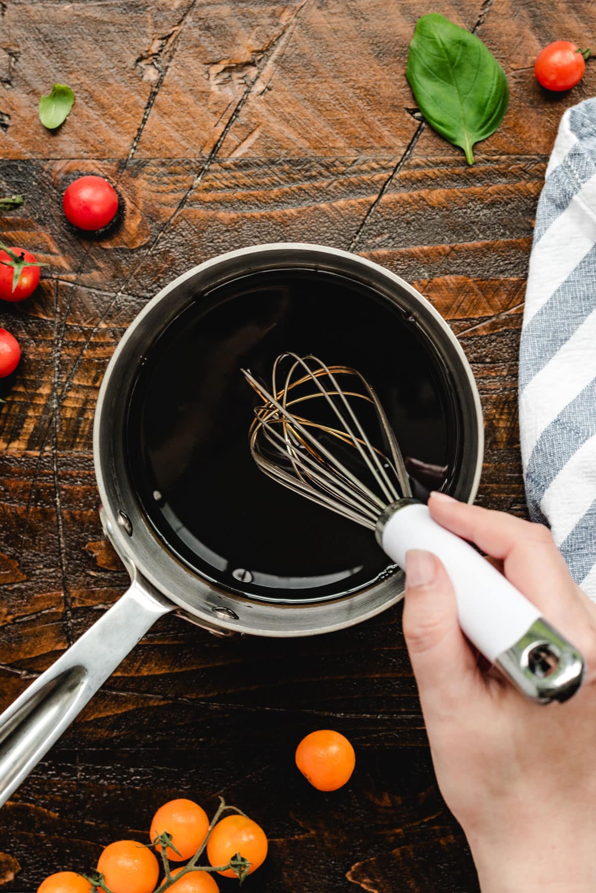 A pot of balsamic glaze being whisked.