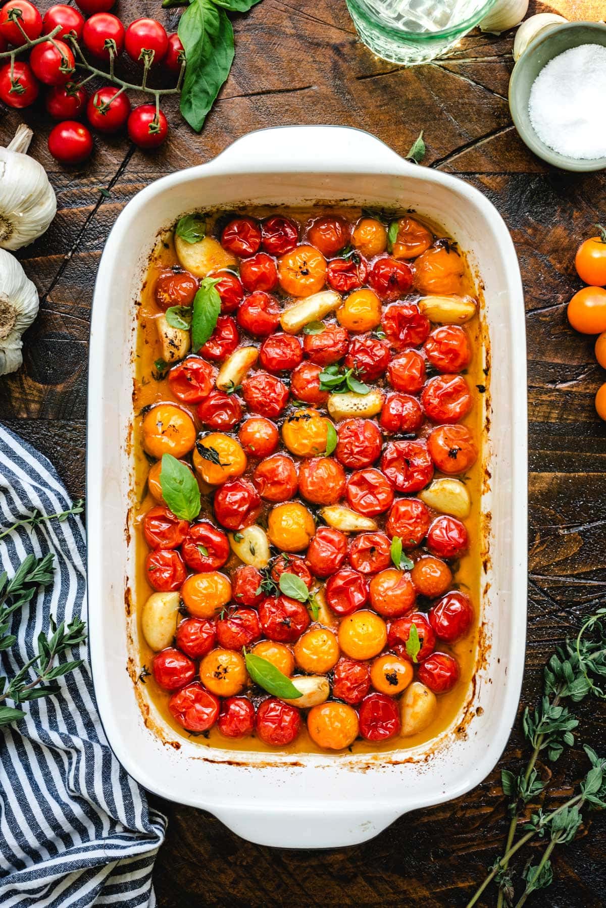 Red, yellow, and orange roasted cherry tomatoes in a rectangular baking dish.