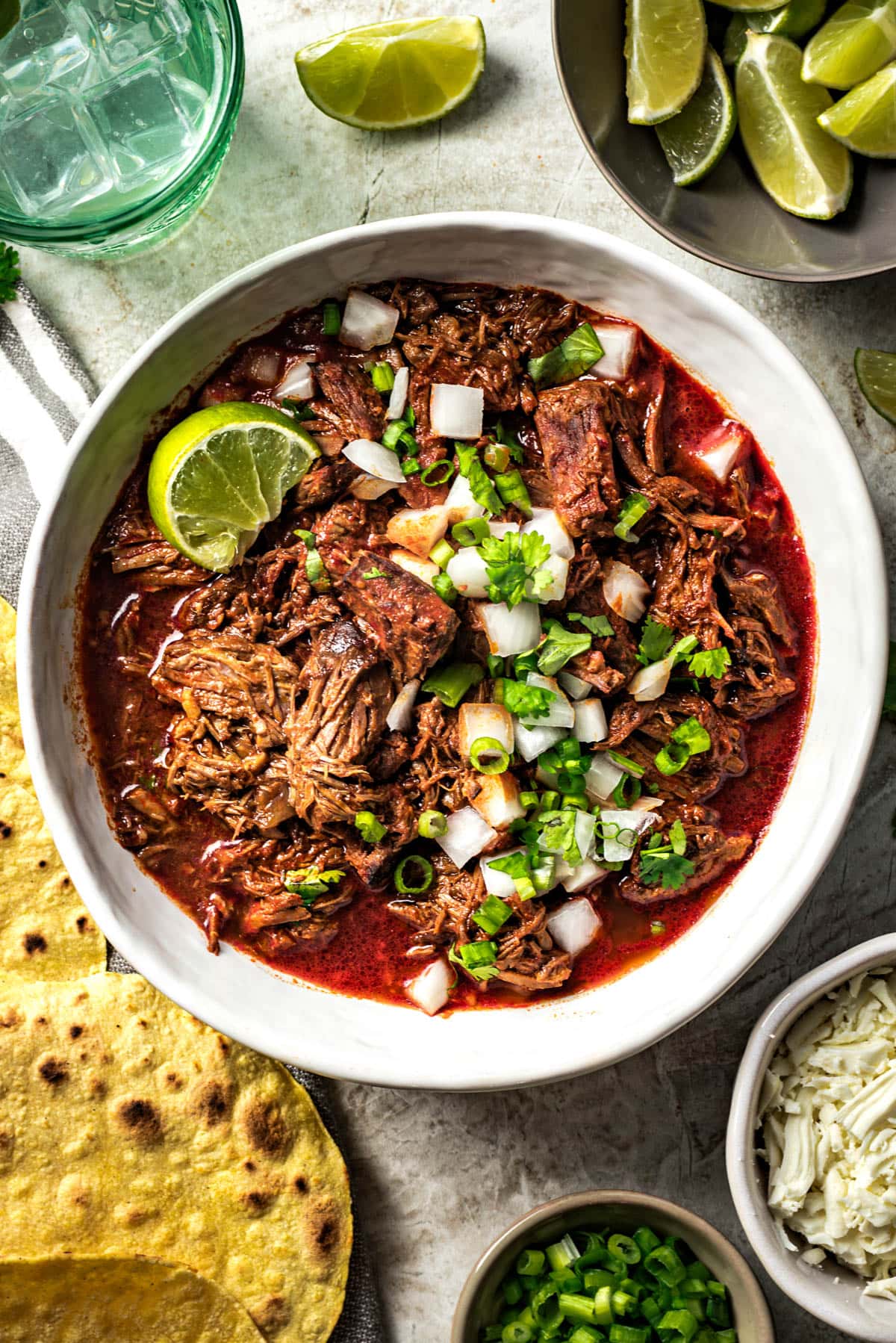 Birria de res served in a bowl with all of the fixings