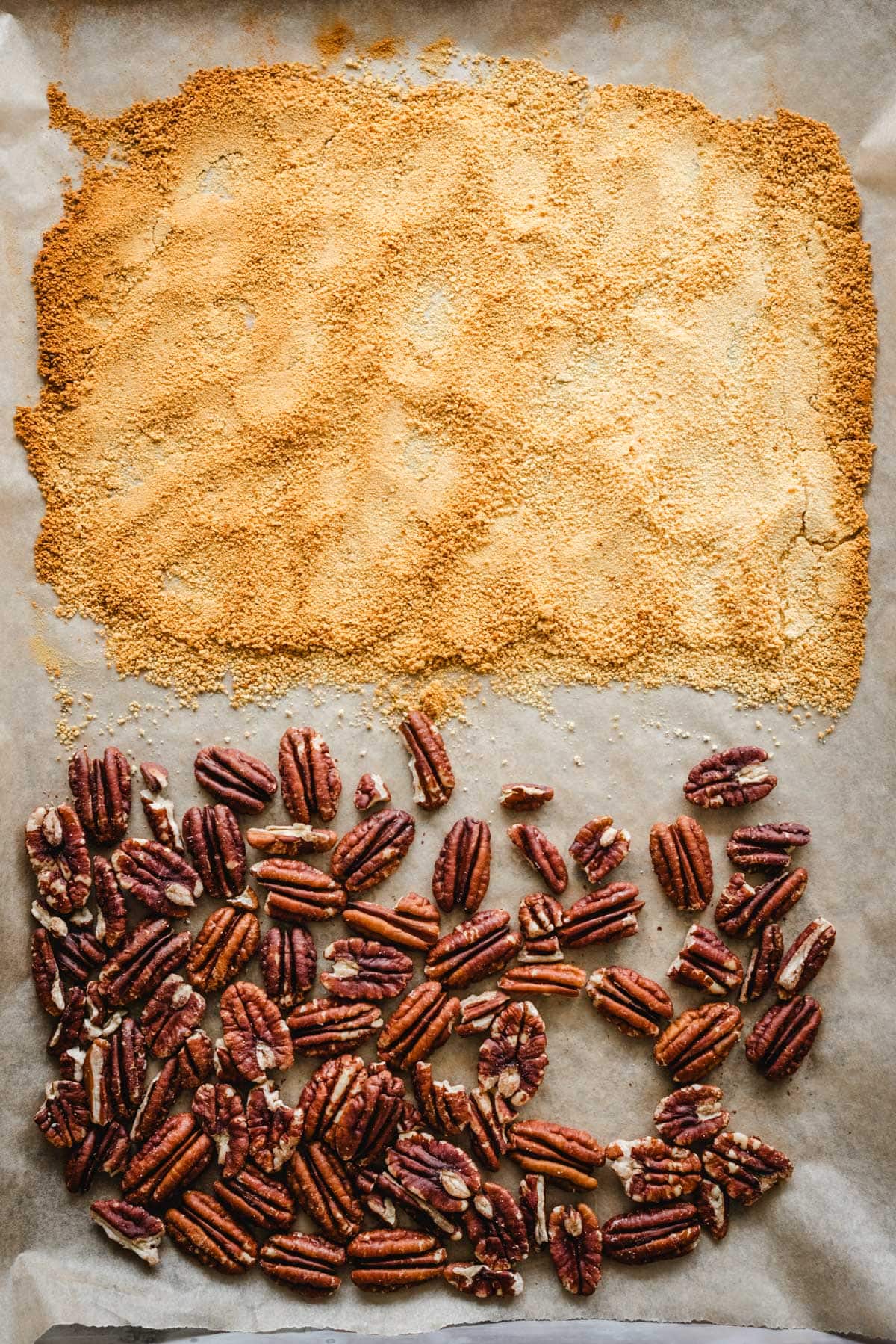 Toasted milk powder and toasted pecans on a sheet pan for carrot cake cupcakes
